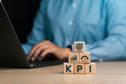 KPI Effective and smart key performance indicators (KPIs) to measure and evaluate progress. Businessman holds wooden blocks with KPI icons. Specific, measurable, achievable, realistic, timely. Tracking performance, setting goals